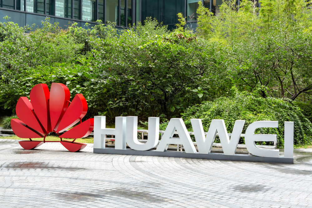 Huawei logo with a plant background.