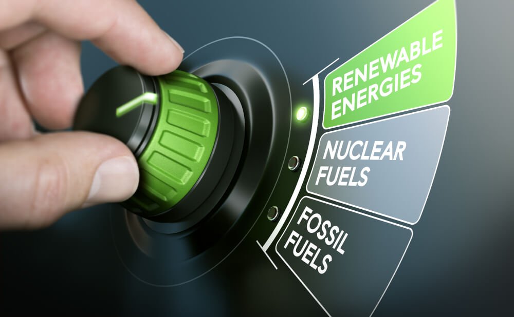 A hand turning an energy transition button to switch from fossil fuels to renewable energies.