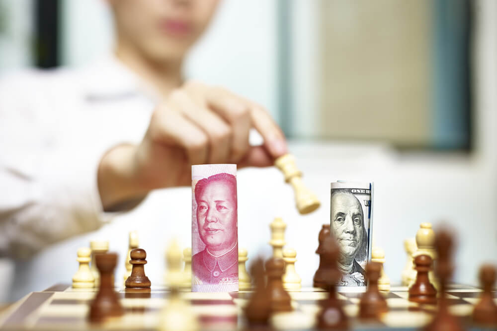 U.S. Dollar (USD) and Chinese Yuan (CNY or RMB) bills on a chess board, concept for currency games.